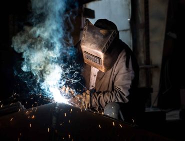 Closeup worker in a mask doing the welding in a workshop